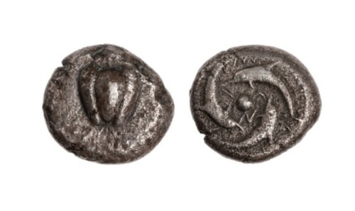 Silver stater of Melo featuring an apple on the obverse and dolphins swimming on the reverse.